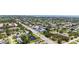 Wide aerial view showcasing the property's location near a bustling street, and close to a tranquil pond and other businesses at 4308 Kingston Loop, Sarasota, FL 34238