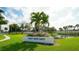 A lush community entrance marked by the sign 'Gulf Gate East' with vibrant flowers and a serene pond backdrop at 4308 Kingston Loop, Sarasota, FL 34238