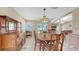 Dining room with wooden table, vintage light, and view into the living room and fireplace at 4308 Kingston Loop, Sarasota, FL 34238