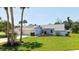 Charming home with a two-car garage, tidy front lawn, and palm trees under a sunny blue sky at 4308 Kingston Loop, Sarasota, FL 34238