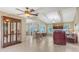 Open living space with tiled floors, beamed ceilings, fireplace, and a display cabinet at 4308 Kingston Loop, Sarasota, FL 34238