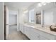 Modern bathroom with double sink vanity, granite countertops, tiled floors, and a shower with a glass door at 4524 Pippin Ln, Lakewood Ranch, FL 34211