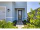 A welcoming walkway leads to the front door, framed by lush greenery and blooming plants at 4524 Pippin Ln, Lakewood Ranch, FL 34211