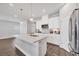 Open-concept kitchen featuring a spacious island, stainless steel appliances, and sleek pendant lighting at 4524 Pippin Ln, Lakewood Ranch, FL 34211