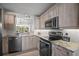 Modern kitchen with stainless steel appliances, granite countertops, and light wood cabinetry at 4530 Pinebrook Cir # 109, Bradenton, FL 34209