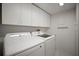 Bright laundry room with overhead cabinets and modern washer and dryer appliances at 4530 Pinebrook Cir # 109, Bradenton, FL 34209