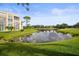 Scenic view of a pond reflecting the sky, surrounded by lush green grass and landscaping near the building at 4530 Pinebrook Cir # 109, Bradenton, FL 34209