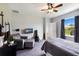This comfortable bedroom features a ceiling fan, a mounted TV, and a large window at 4739 Reisswood Loop, Palmetto, FL 34221