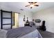 Cozy bedroom features a sliding barn door to ensuite bathroom with a ceiling fan and mounted television at 4739 Reisswood Loop, Palmetto, FL 34221