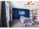 The bedroom features a statement wall, modern fan, and an ensuite bath with frosted sliding door at 4739 Reisswood Loop, Palmetto, FL 34221