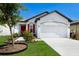 Charming one-story home with a well-manicured lawn, colorful flowers, and a bright red front door at 4739 Reisswood Loop, Palmetto, FL 34221