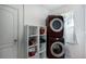 Laundry room with stacked washer and dryer, storage shelves, and a window for natural light at 4739 Reisswood Loop, Palmetto, FL 34221