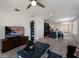 Bright living room with sleek tile flooring, a ceiling fan, and a view leading to a modern kitchen at 4739 Reisswood Loop, Palmetto, FL 34221