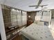 Well-lit bedroom with paneled walls, hardwood floors, shelving, and ceiling fan at 5301 Algeria Ct, Bradenton, FL 34207