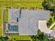 An aerial view of the home showing the roof, driveway, landscaping, and screened-in pool at 5373 Anthony Ln, Sarasota, FL 34233