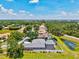 The aerial view captures the home, pool, pond and surrounding lush landscape at 5373 Anthony Ln, Sarasota, FL 34233