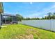A spacious backyard with a well-maintained lawn, a screened-in patio and a privacy fence at 5373 Anthony Ln, Sarasota, FL 34233