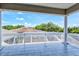 A spacious balcony with tiled floors and a scenic view of the surrounding trees and neighborhood at 5373 Anthony Ln, Sarasota, FL 34233