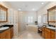 Luxury bathroom features a glass block shower, soaking tub, double sinks, and black countertops at 5373 Anthony Ln, Sarasota, FL 34233