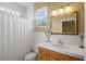 Well-lit bathroom with a tiled countertop, a decorative mirror, and a shower with a curtain at 5373 Anthony Ln, Sarasota, FL 34233