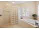 Elegant bathroom features a glass-enclosed shower and a soaking tub by the window at 5373 Anthony Ln, Sarasota, FL 34233