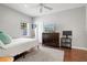 Bedroom with wood floor, white walls, ceiling fan, TV and view of the back yard from window at 5373 Anthony Ln, Sarasota, FL 34233