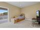 Bright bedroom with light colored carpet, a balcony, and a TV stand with TV at 5373 Anthony Ln, Sarasota, FL 34233