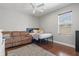 Cozy bedroom featuring hardwood floors, a ceiling fan, and a bright window at 5373 Anthony Ln, Sarasota, FL 34233