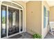 Stylish front entrance with a decorative glass door, blue shutters, and manicured plants at 5373 Anthony Ln, Sarasota, FL 34233