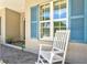 Close up of the front porch with rocking chair and blue shutters at 5373 Anthony Ln, Sarasota, FL 34233