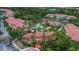 An aerial view showcases a community pool and clubhouse surrounded by tropical landscaping and multiple residential buildings at 5401 Bentgrass Dr # 1-113, Sarasota, FL 34235