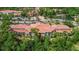 Scenic aerial of community buildings, landscaping and parking, near a tranquil pond at 5401 Bentgrass Dr # 1-113, Sarasota, FL 34235