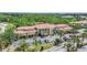 Aerial view of a modern residential building featuring lush landscaping and a well-maintained parking area at 5401 Bentgrass Dr # 1-113, Sarasota, FL 34235