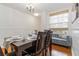 An elegant dining area with chandelier, wooden table and cushioned window seat at 5401 Bentgrass Dr # 1-113, Sarasota, FL 34235