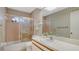 Well-lit bathroom featuring a shower-tub combination with glass door and a vanity with a large mirror at 5613 Sweetwater Oak Dr, Sarasota, FL 34232