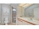 Well-lit bathroom featuring a toilet, shower with glass door, and vanity with a large mirror at 5613 Sweetwater Oak Dr, Sarasota, FL 34232