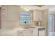 Bright kitchen with white cabinets, laminate countertops, and stainless dishwasher at 5613 Sweetwater Oak Dr, Sarasota, FL 34232