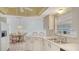 Bright kitchen featuring white cabinets and appliances with open breakfast nook area at 5613 Sweetwater Oak Dr, Sarasota, FL 34232