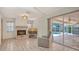 Cozy living room features a fireplace, tile flooring, and sliding glass doors to the screened lanai at 5613 Sweetwater Oak Dr, Sarasota, FL 34232