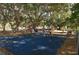 Gathering-friendly playground with a blue safety surface and a variety of colorful play equipment under mature trees at 5613 Sweetwater Oak Dr, Sarasota, FL 34232