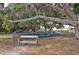 Outdoor playground area featuring swings, slides, and a bench for relaxation, all set within a grassy park at 5613 Sweetwater Oak Dr, Sarasota, FL 34232