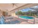 Relaxing screened-in pool area with lounge chairs and views of the backyard at 5613 Sweetwater Oak Dr, Sarasota, FL 34232