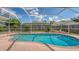 A serene screened-in pool featuring lush landscaping and a concrete patio at 5613 Sweetwater Oak Dr, Sarasota, FL 34232