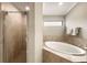 Bathroom featuring a soaking tub, tiled walls, and a glass shower at 5624 Palmer Cir # 206, Bradenton, FL 34211