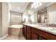 Bathroom featuring a double vanity, granite countertops, and a soaking tub at 5624 Palmer Cir # 206, Bradenton, FL 34211