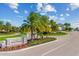 Community entrance featuring lush landscaping, palm trees, and a stone 'Lakewood National' sign at 5624 Palmer Cir # 206, Bradenton, FL 34211