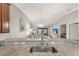 Close-up of kitchen with sink, granite countertops, and view of living area with golf course views at 5624 Palmer Cir # 206, Bradenton, FL 34211