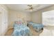 Bright bedroom featuring twin beds, a ceiling fan, and ample natural light from the large window at 6108 7Th W Ave # 6108, Bradenton, FL 34209