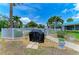 Community grill area with a cover and a view of the white picket fence and tropical landscaping and pool in the background at 6108 7Th W Ave # 6108, Bradenton, FL 34209