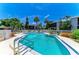 Community pool surrounded by tropical foliage and landscaping with lounge chairs and condos in the background at 6108 7Th W Ave # 6108, Bradenton, FL 34209